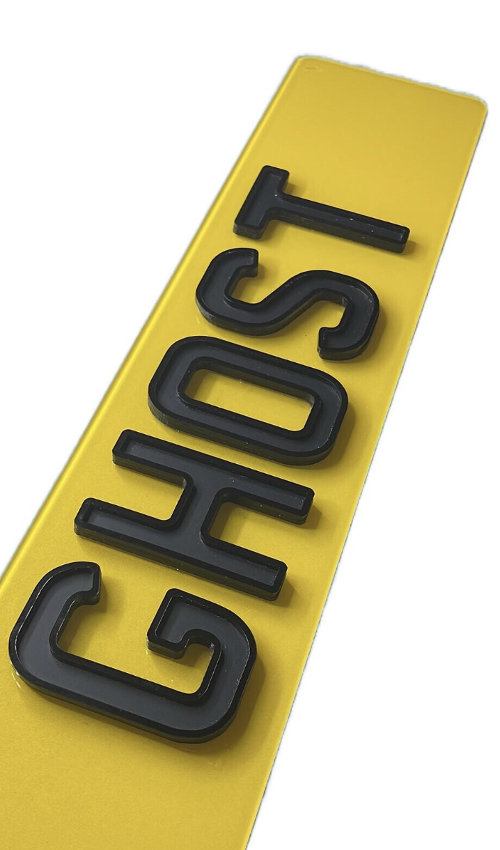 Angled close-up of a Dyno Details 4D ghost plate showing raised outlined black characters